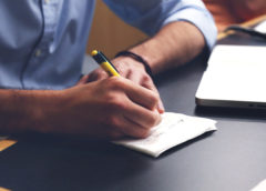 man writing on paper